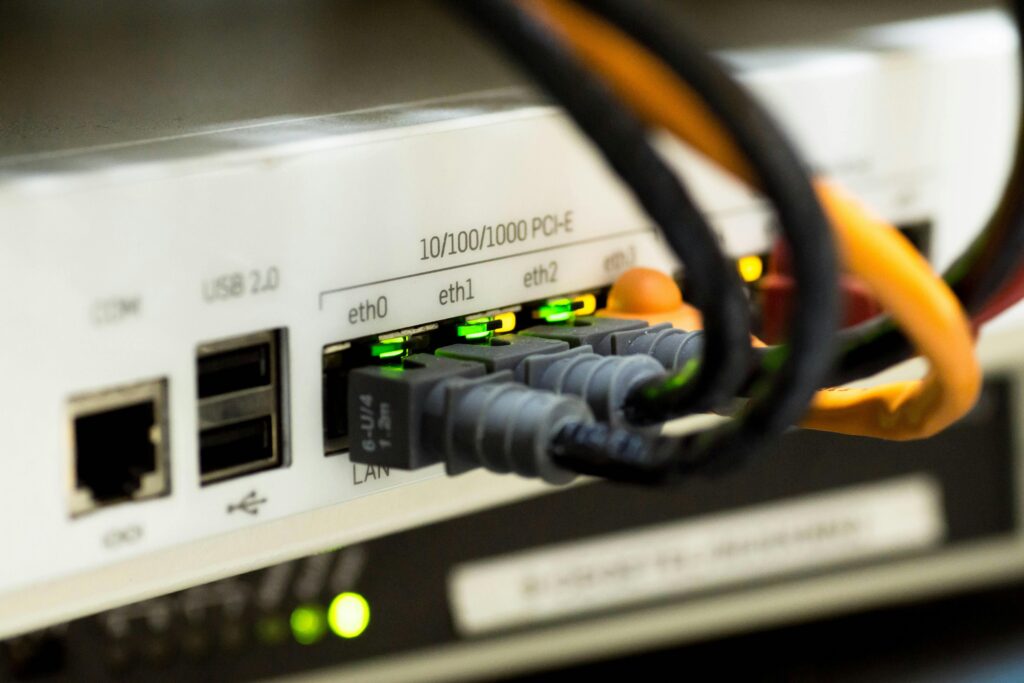 Router sieciowy z podłączonymi kablami Ethernet – infrastruktura IT wspierająca analizę danych i procesy cjn