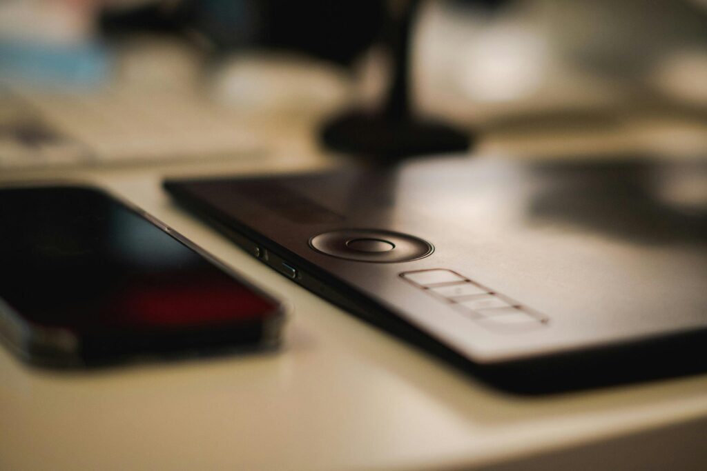 Tablet graficzny na biurku obok smartfona, narzędzie do tworzenia grafiki cyfrowej, porównanie grafiki wektorowej i rastrowej w projektowaniu graficznym