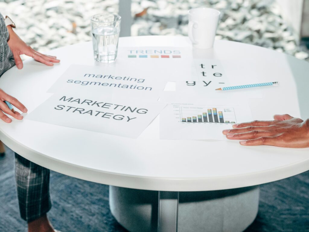 Materiały strategiczne na stole z wykresami i hasłami marketingowymi, marketing wizualny oparty na danych, wykorzystanie infografik, trendów i strategii w komunikacji marketingowej